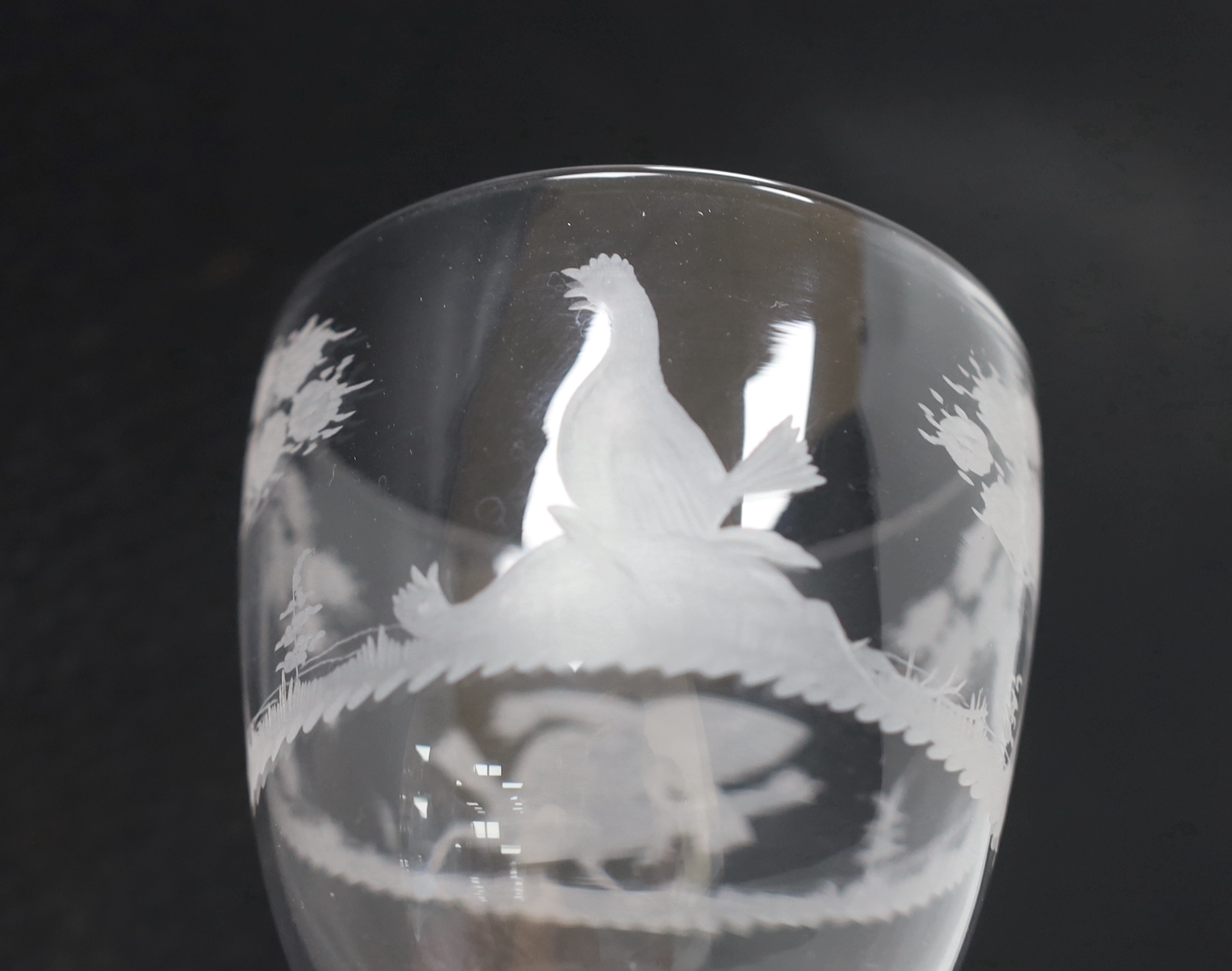 An English lead crystal facet stem goblet, c.1780, round funnel bowl, with hexagonal facet stem, conical foot, engraved in the round with trees and cock fighting scenes, 18.6cm